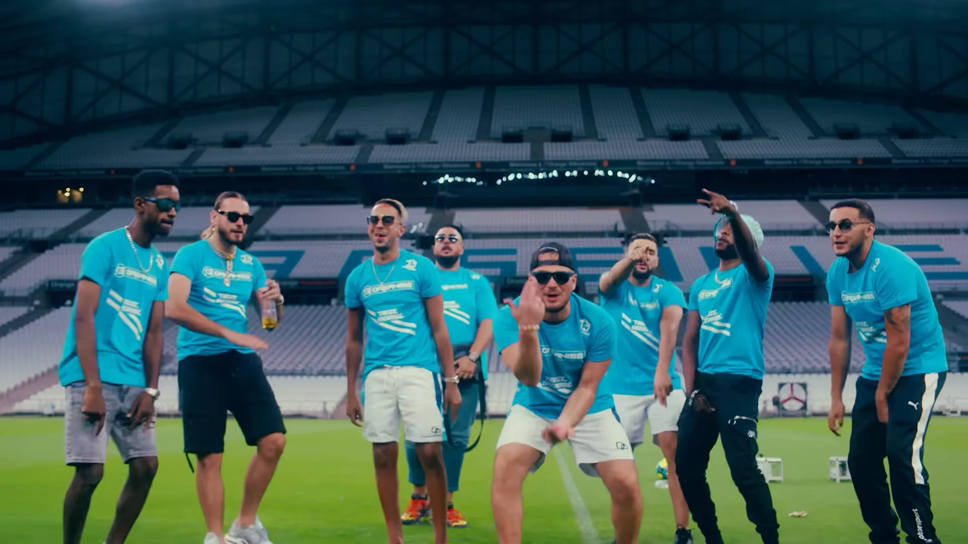 Une dizaine de rappeurs en tee-shirts turquoise dansent sur la pelouse de l’Orange Vélodrome vide, sous la toiture du stade.
