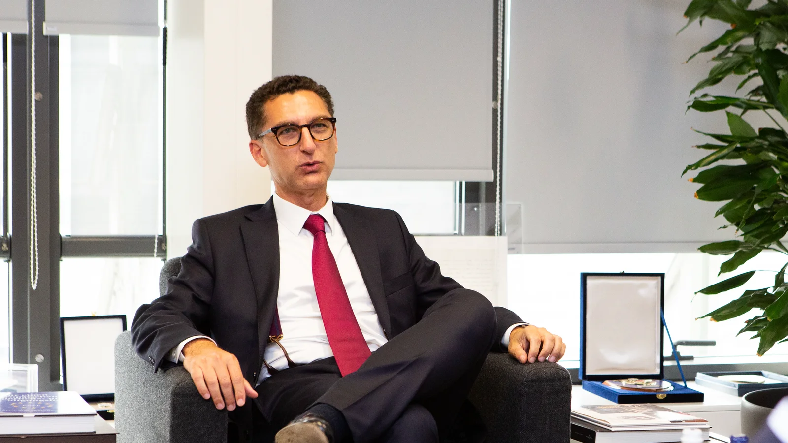 Maxime Saada, président du directoire de Canal+, en costume sombre et cravate rouge, assis dans un fauteuil, s’exprime lors d’un entretien dans un bureau de la Commission européenne.