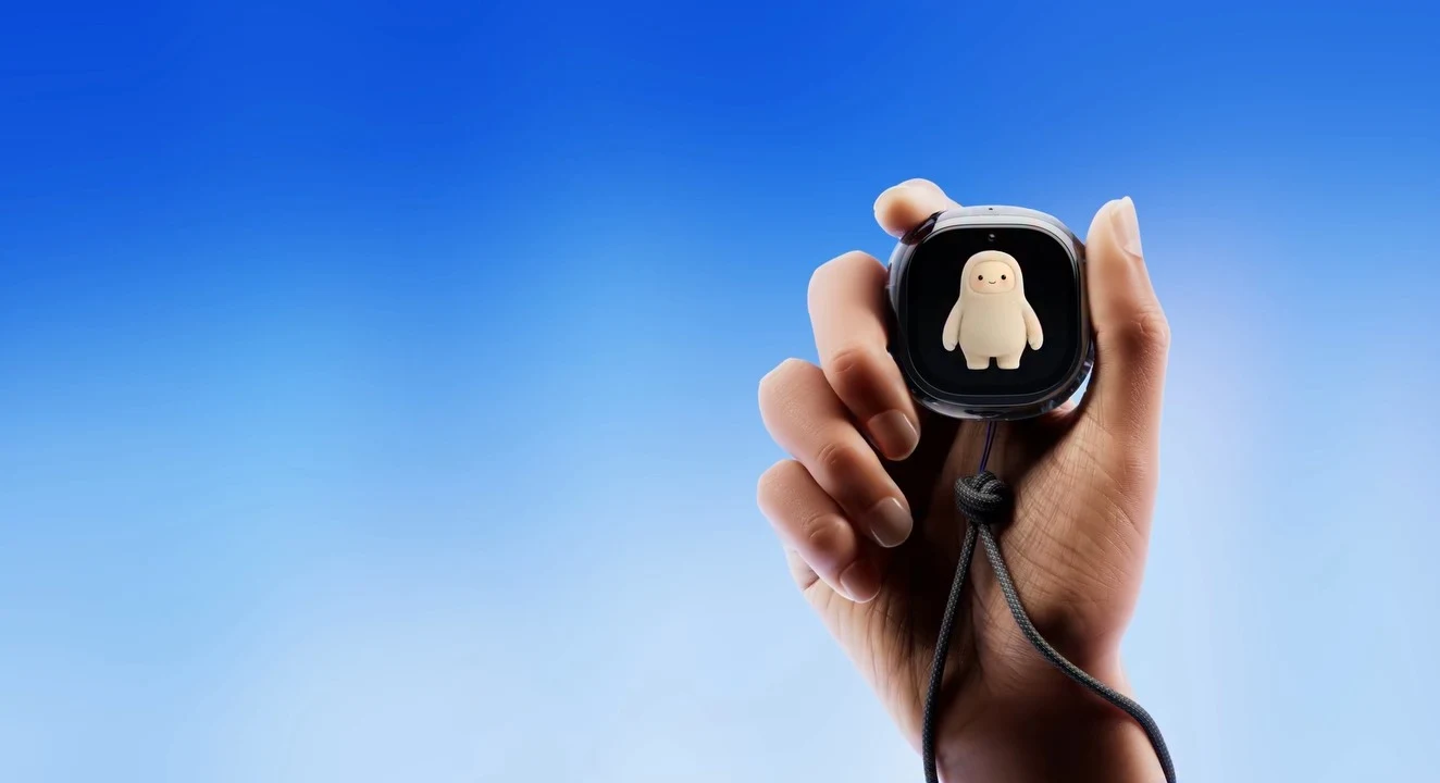 Une main tient le Muse Charm de Meta ; son écran affiche l'avatar de Muse sur fond bleu.