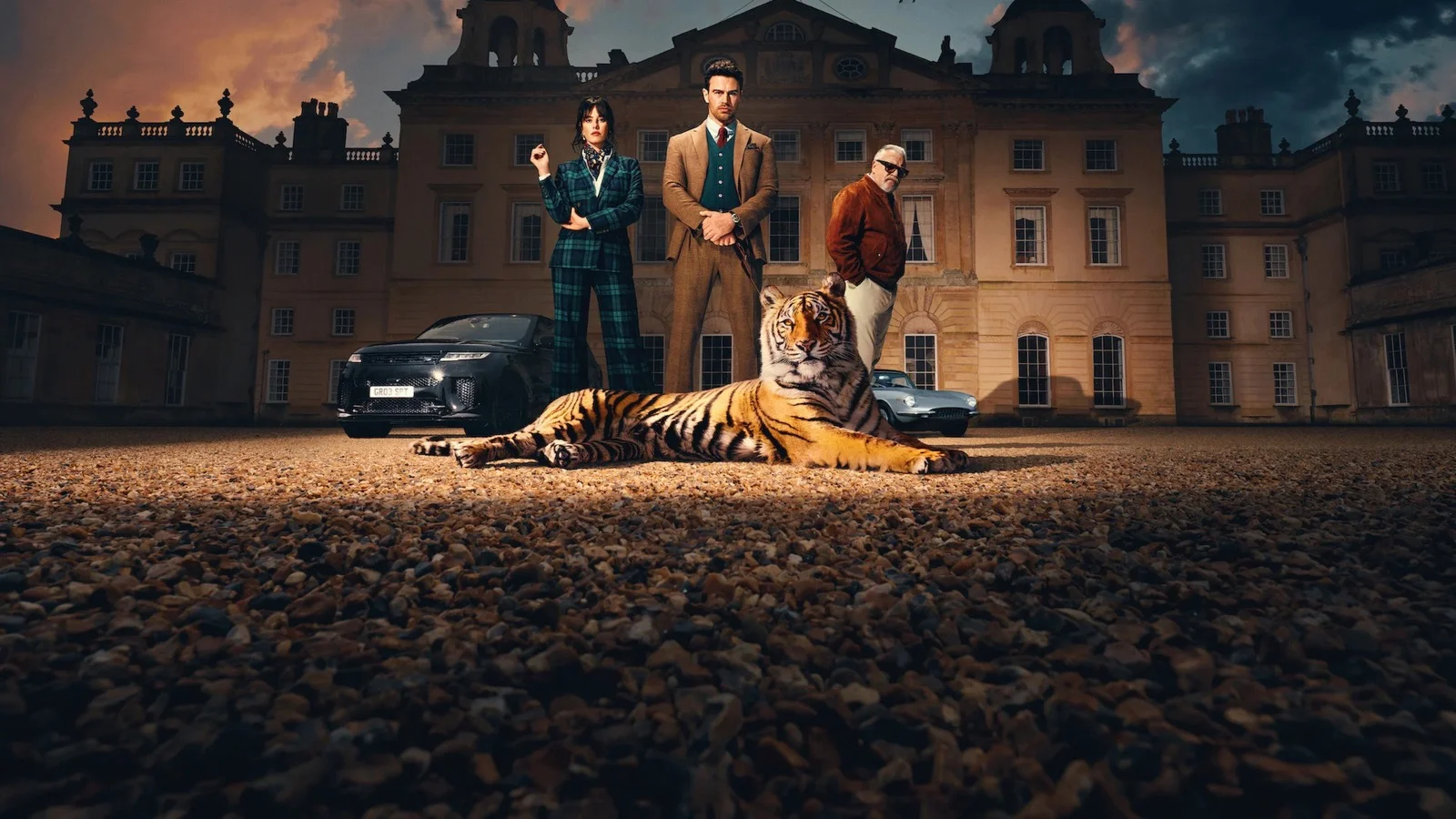 Les personnages de la série The Gentlemen posent devant un manoir anglais, un tigre allongé à leurs pieds.