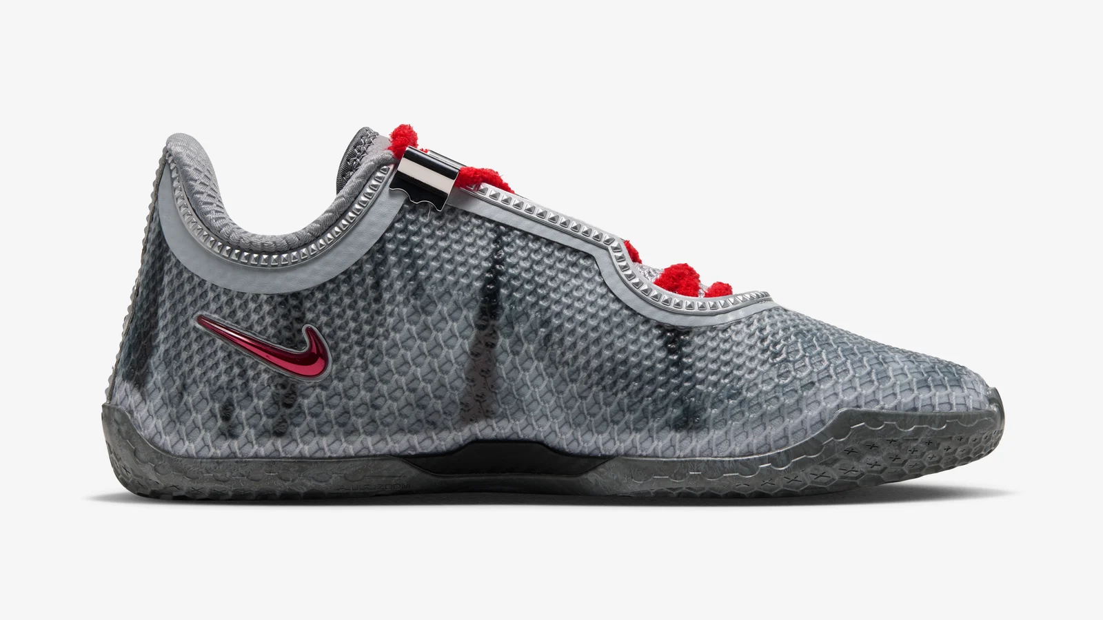 Profil intérieur de la LeBron XXIV « Storm Drain » : tige grise imprimée de coulures noires, Swoosh rouge vernis, semelle grise translucide.