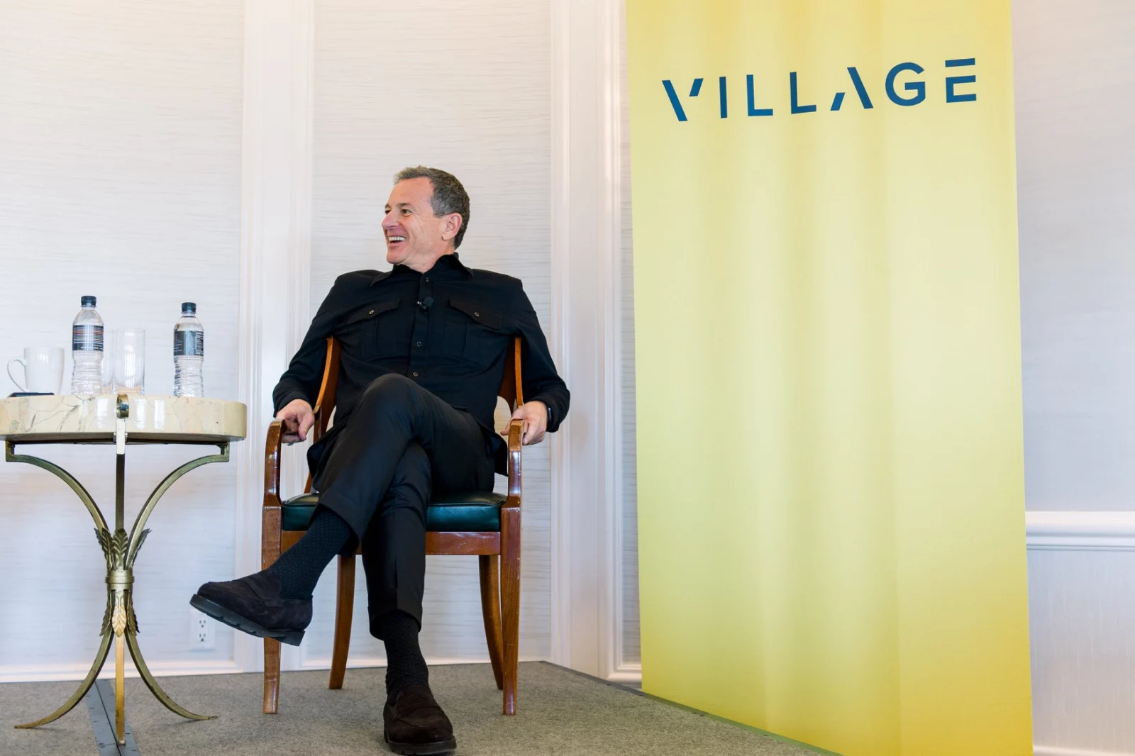 Bob Iger, assis dans un fauteuil devant un panneau Village Global, pendant un entretien public.