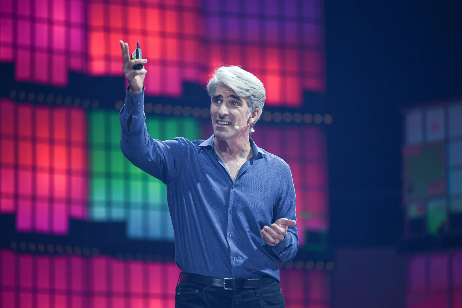 Craig Federighi, micro sur la joue et télécommande à la main, sur la scène du Web Summit 2021.