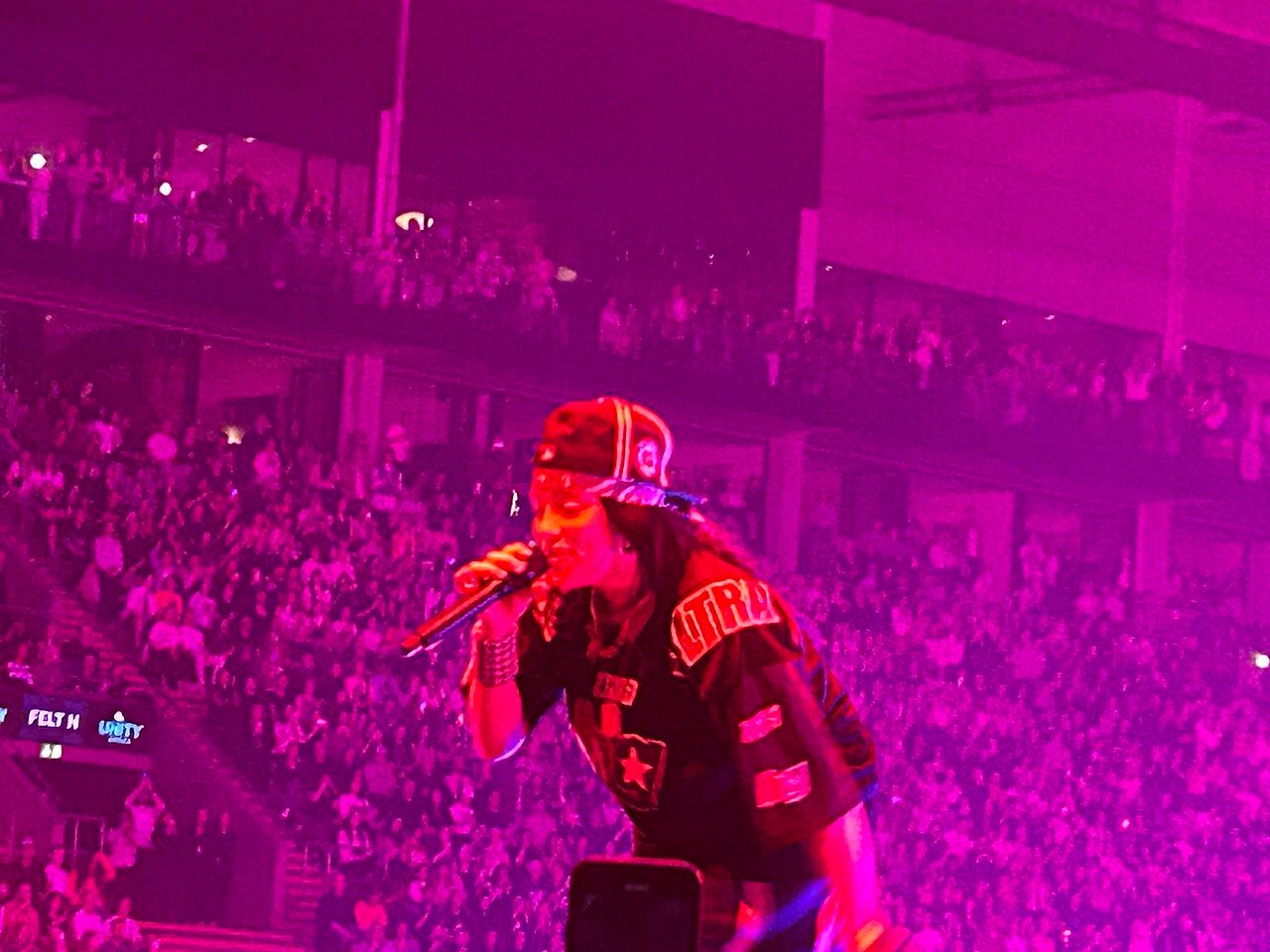 Billie Eilish chante sur scène devant le public d’Oslo sous un éclairage rose et violet en 2025.