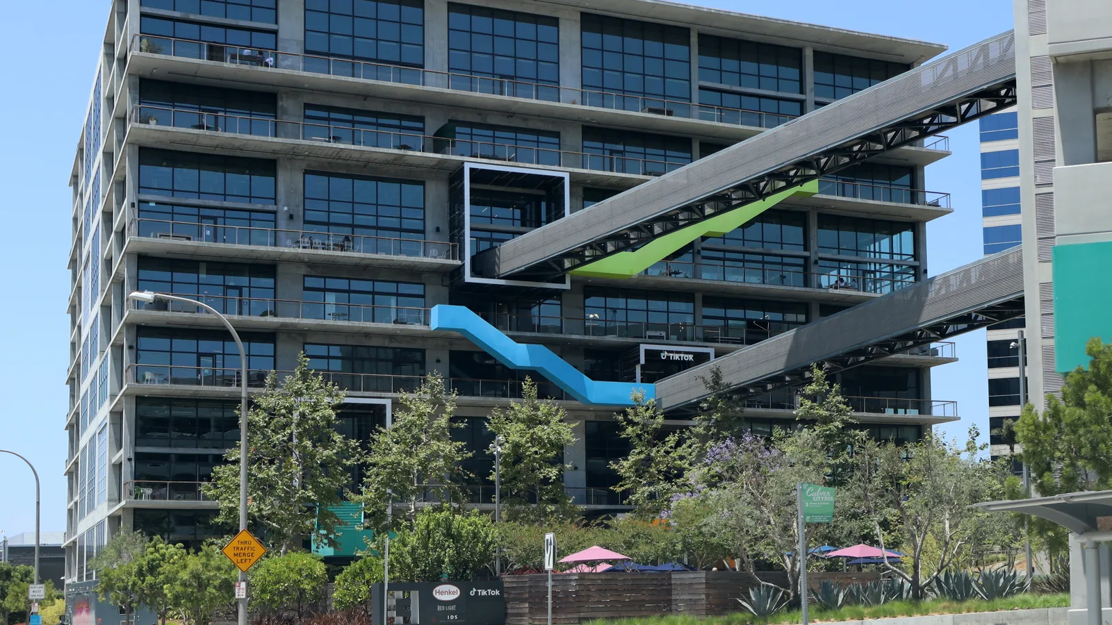 L’ancien siège de TikTok à Culver City, en Californie : un immeuble de verre traversé de passerelles bleue et verte.
