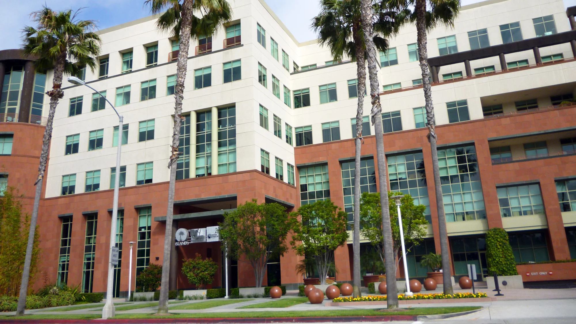 Le siège opérationnel d’Universal Music Group à Santa Monica, en Californie : un immeuble de bureaux beige et brique bordé de palmiers, avec à l’entrée les enseignes des labels Island, Def Jam et Universal Republic.