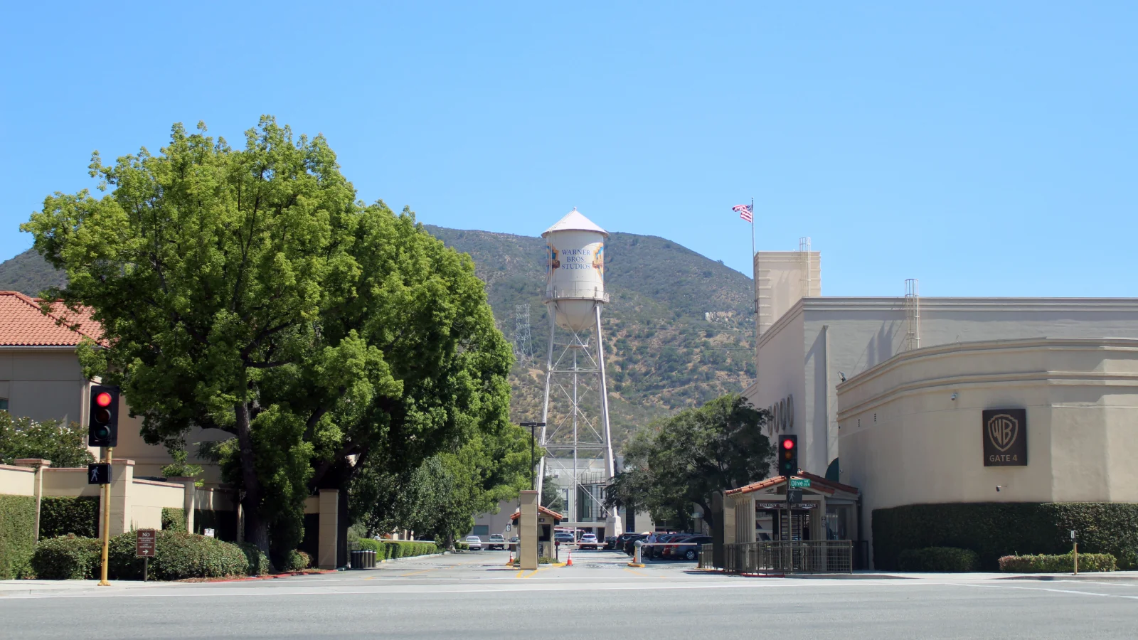 Entrée Gate 4 des studios Warner Bros. à Burbank, avec le château d'eau du studio au fond et les collines sous un ciel bleu