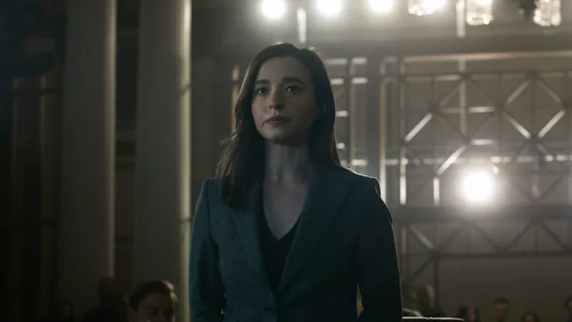 Image officielle de The Social Reckoning : une femme debout dans une salle sous les projecteurs.